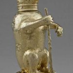 Standing cup; silver-gilt; chased; form of bear seated on hind quarters and grasping staff with right paw
