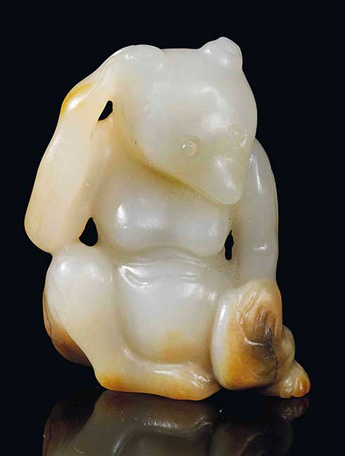 A SMALL WHITE AND RUSSET JADE CARVING OF A BEAR